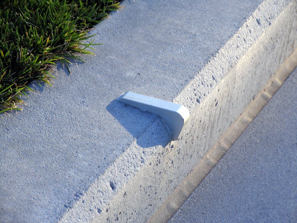 a cement curb on the corner of a street