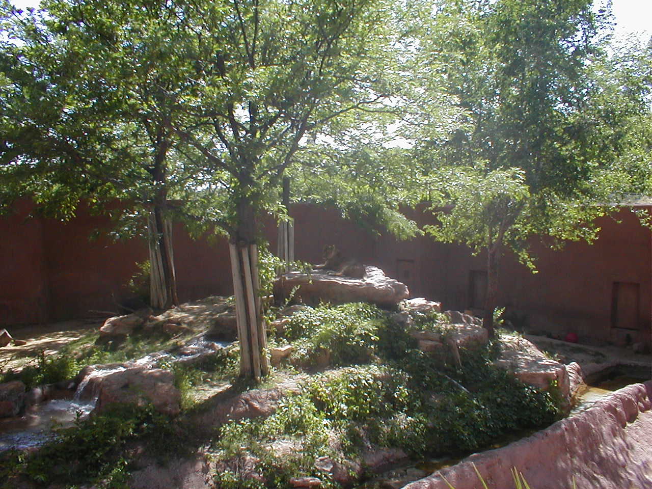 an adobe building in the wild with several small boulders