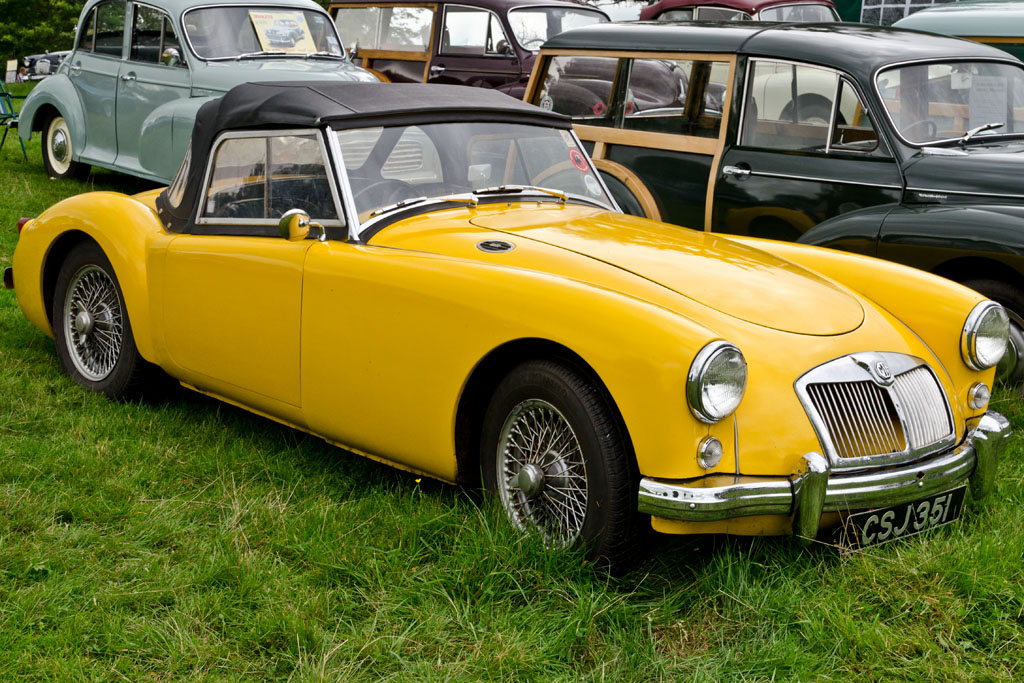 several vintage cars that are parked on the grass