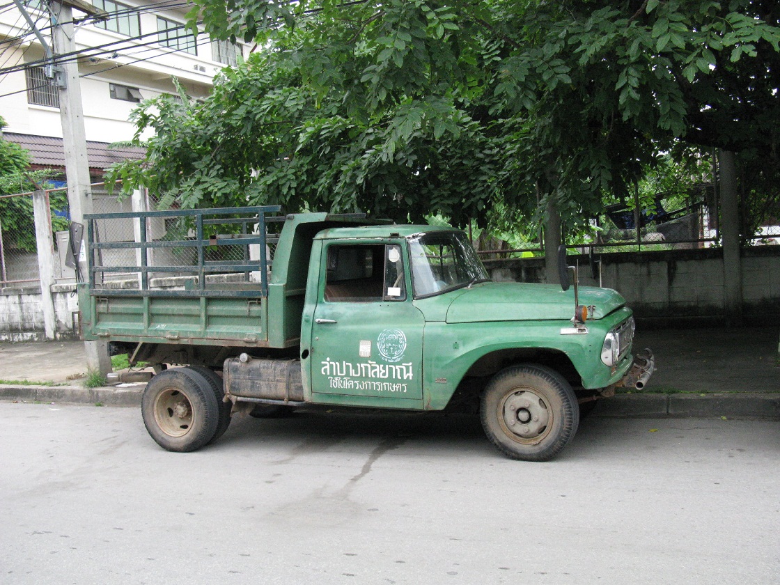 a green truck that is parked on the side of a road