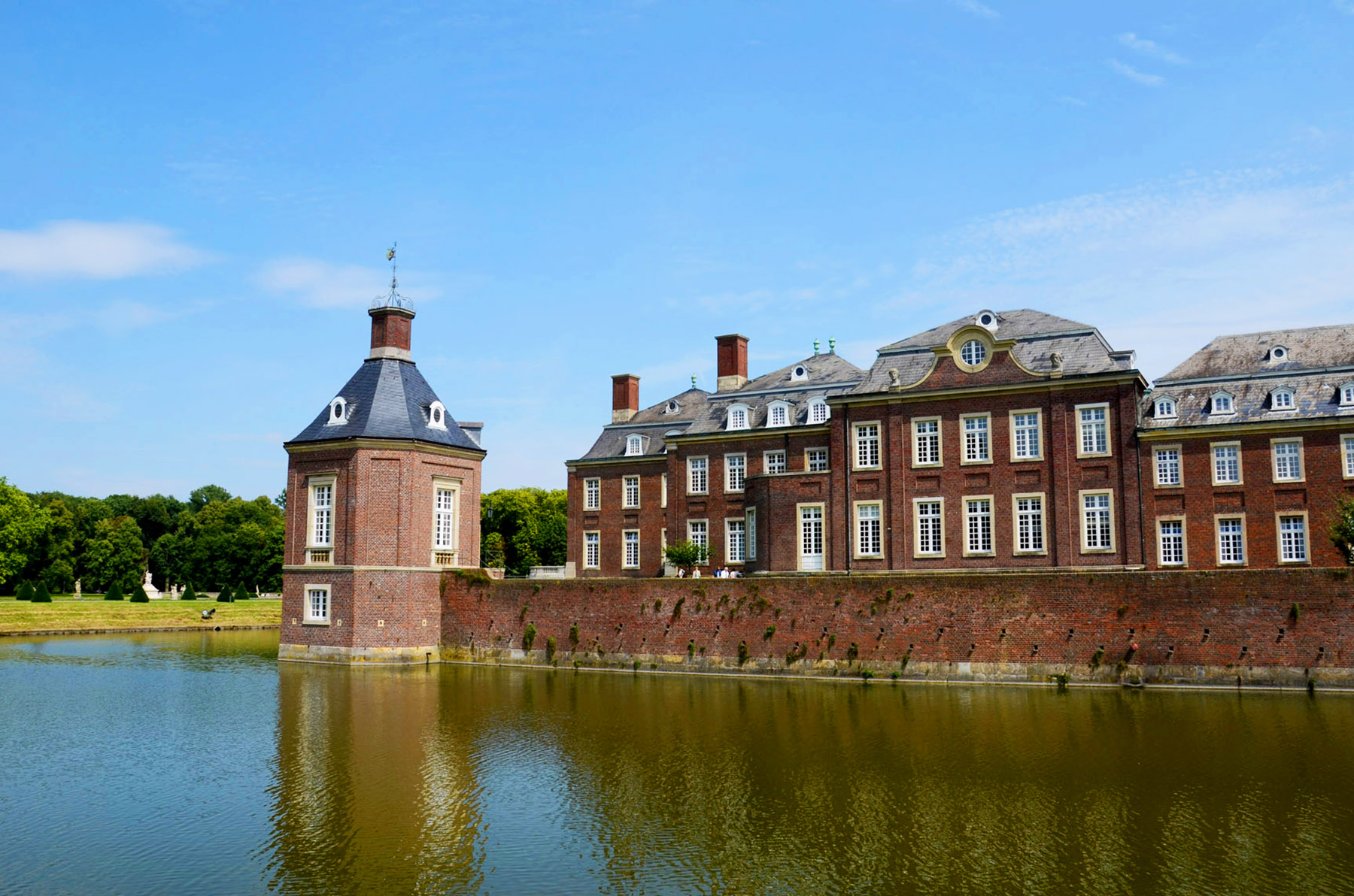 a pond in front of a large brick building