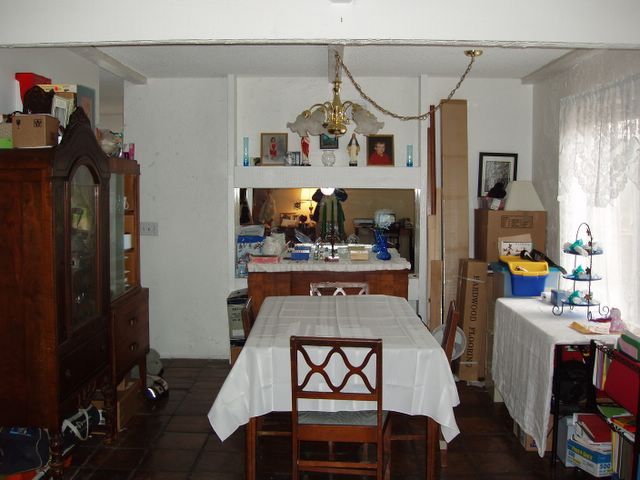 a dining room and kitchen area with dining table and a television