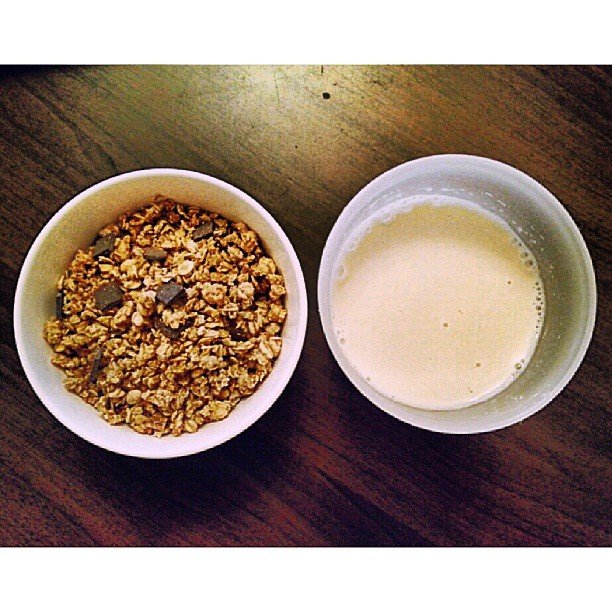 two bowls of cereal next to a cup of milk