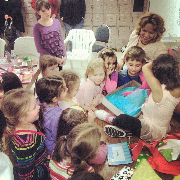 a group of children are gathered around a table