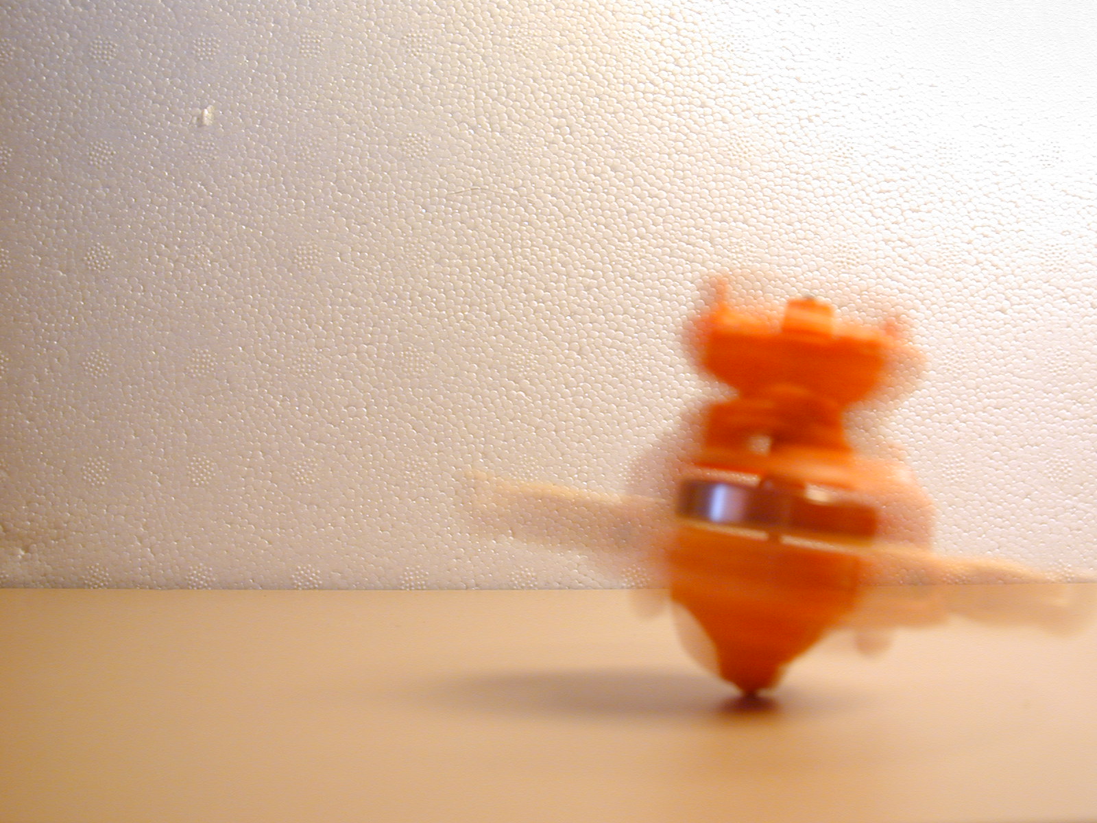 a plastic figurine sits on a white table