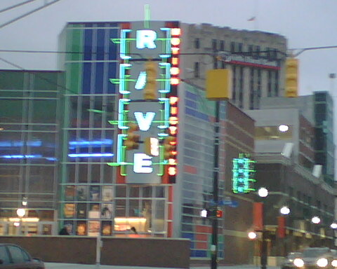a tall building with neon lights on the outside