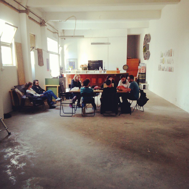 group of people sitting around tables in an office setting