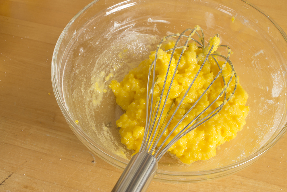 a bowl with batter, egg and a whisk in it