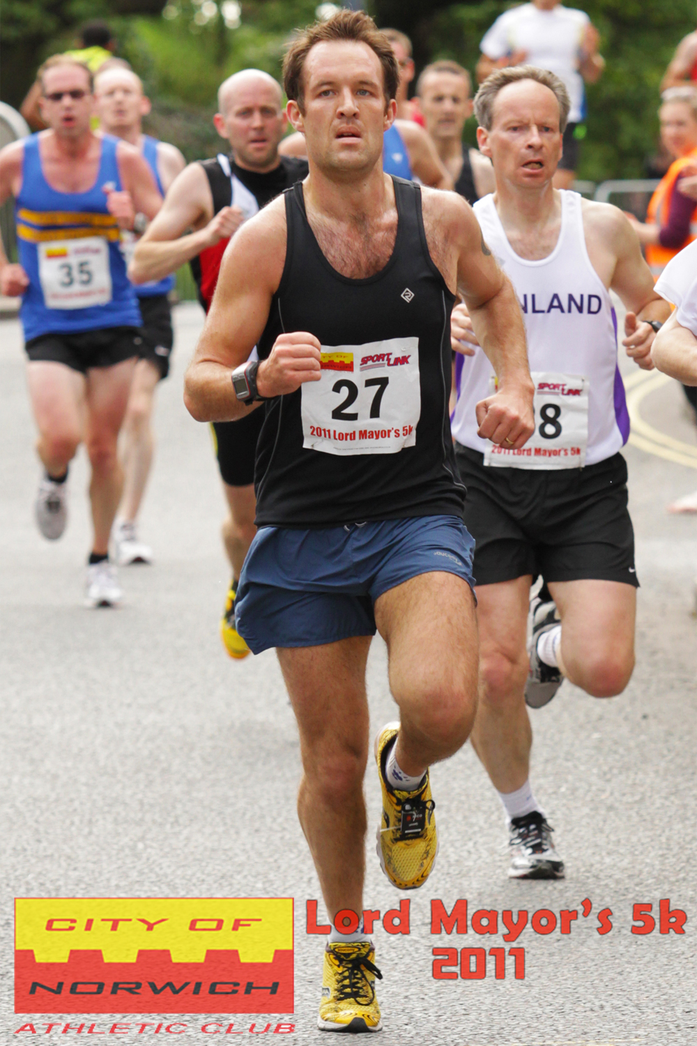 three men run a race in the street