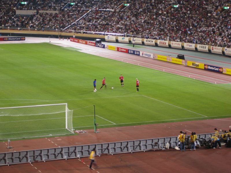 several people on a field playing soccer with fans