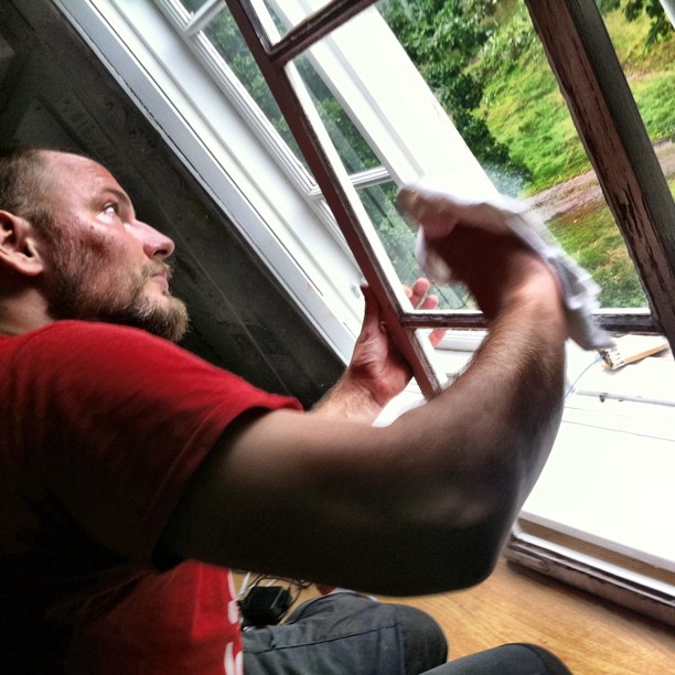 a man is sitting by the window with a towel on his hand