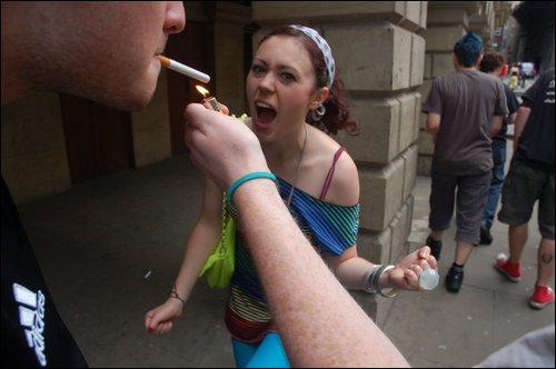 a man lights a cigarette in a woman's mouth