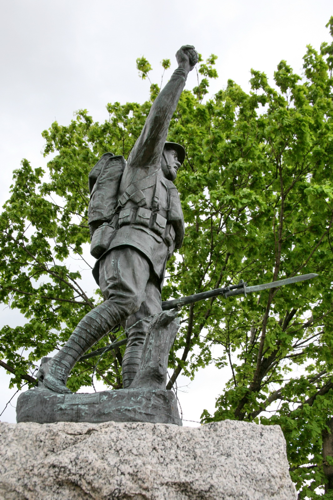 a sculpture of a soldier holding a rifle on top of a rock
