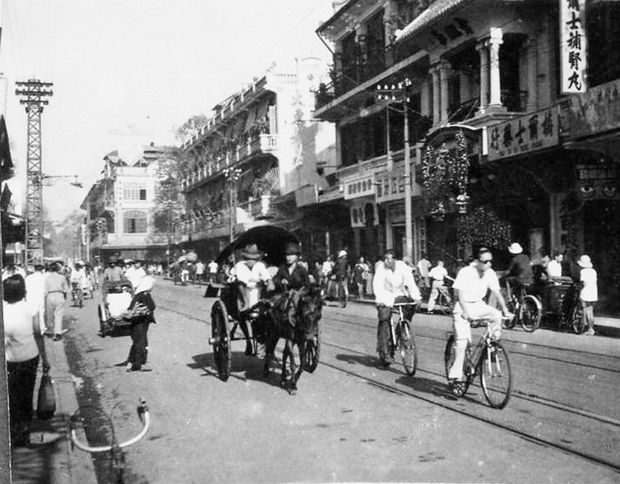 people on bicycles, carriages and carriages on a city street