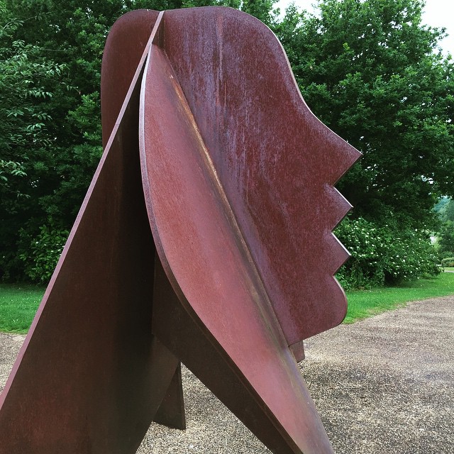 a metal sculpture is in the middle of an open park