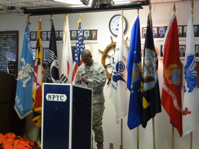 a man standing behind a podium in front of some flags