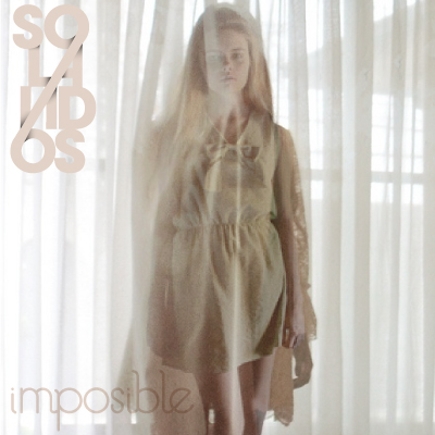 the cover of impossible magazine showing a young woman wearing a tan dress