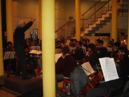 a conductor and orchestra in the audience