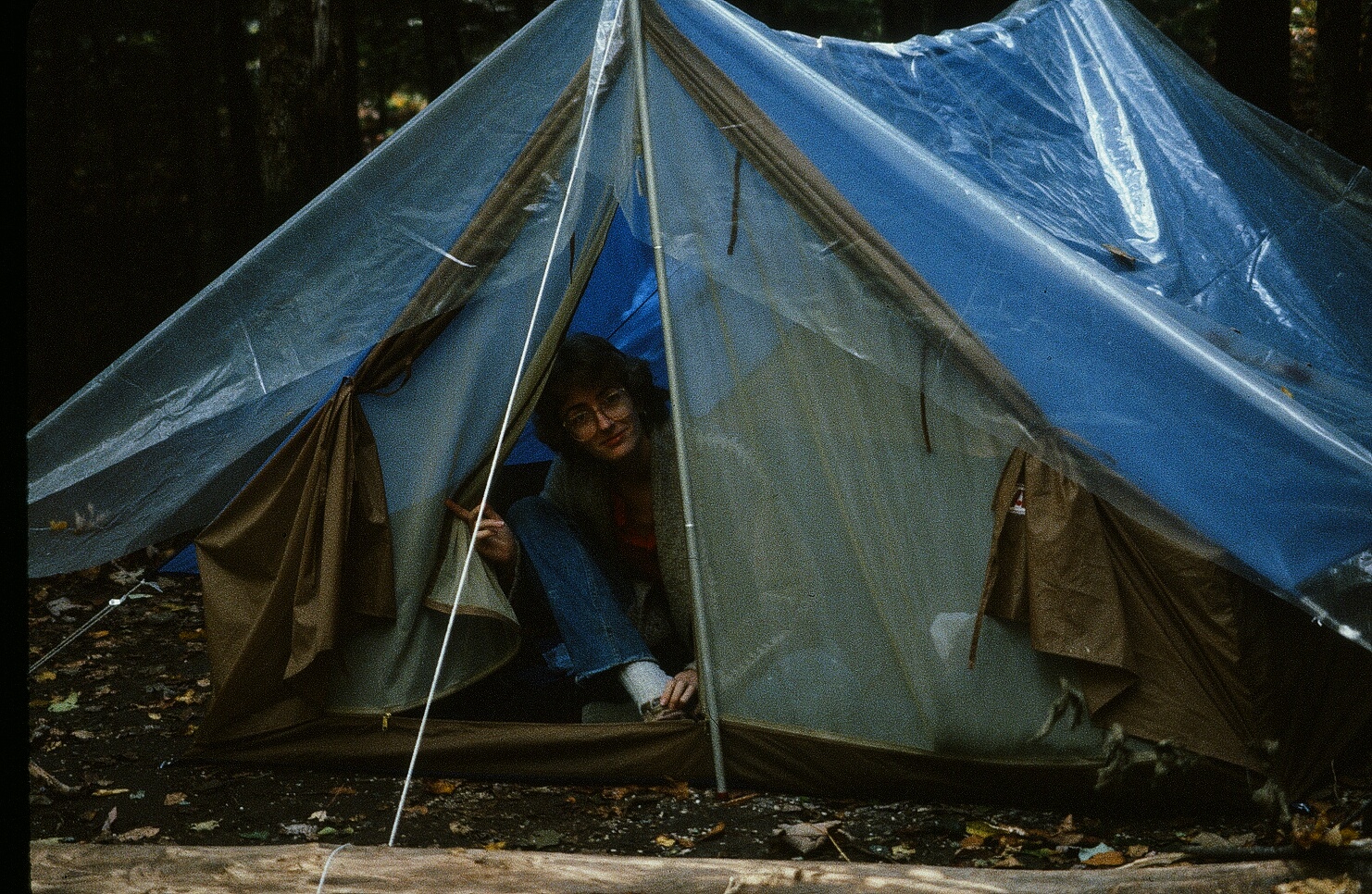 a man sits inside a tent while looking in the window