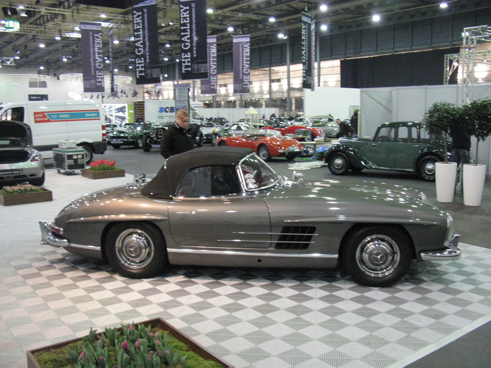 a man standing next to a grey and white car