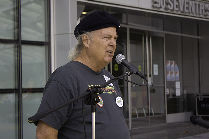 an older man standing in front of a microphone