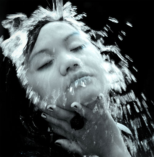 a young woman with her face and hands submerged in water
