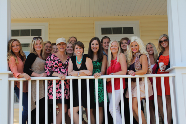 a group of young women posing together on a porch