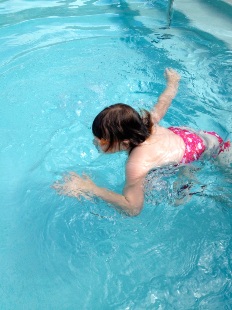 a child plays in the water in a pool