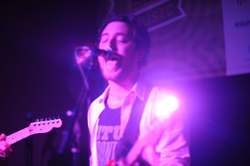 man with beard playing a guitar at a music event