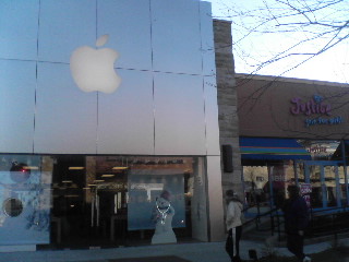 an apple store in the city with people walking by