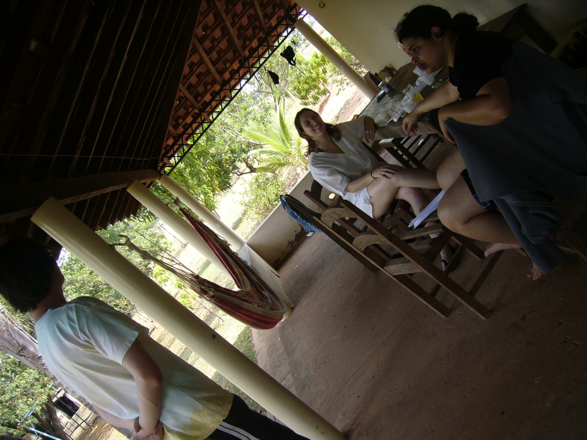 there are some people eating outside next to a hammock