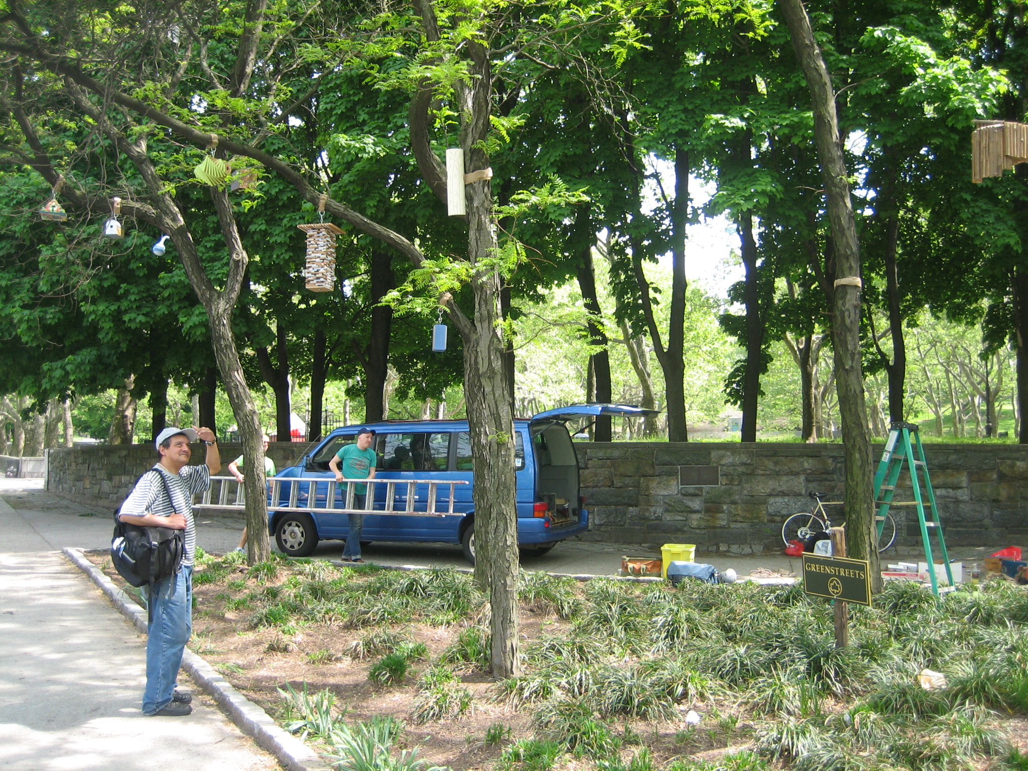 a man standing on a sidewalk next to trees