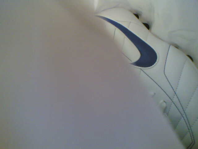 the side view of a white and blue nike shoe