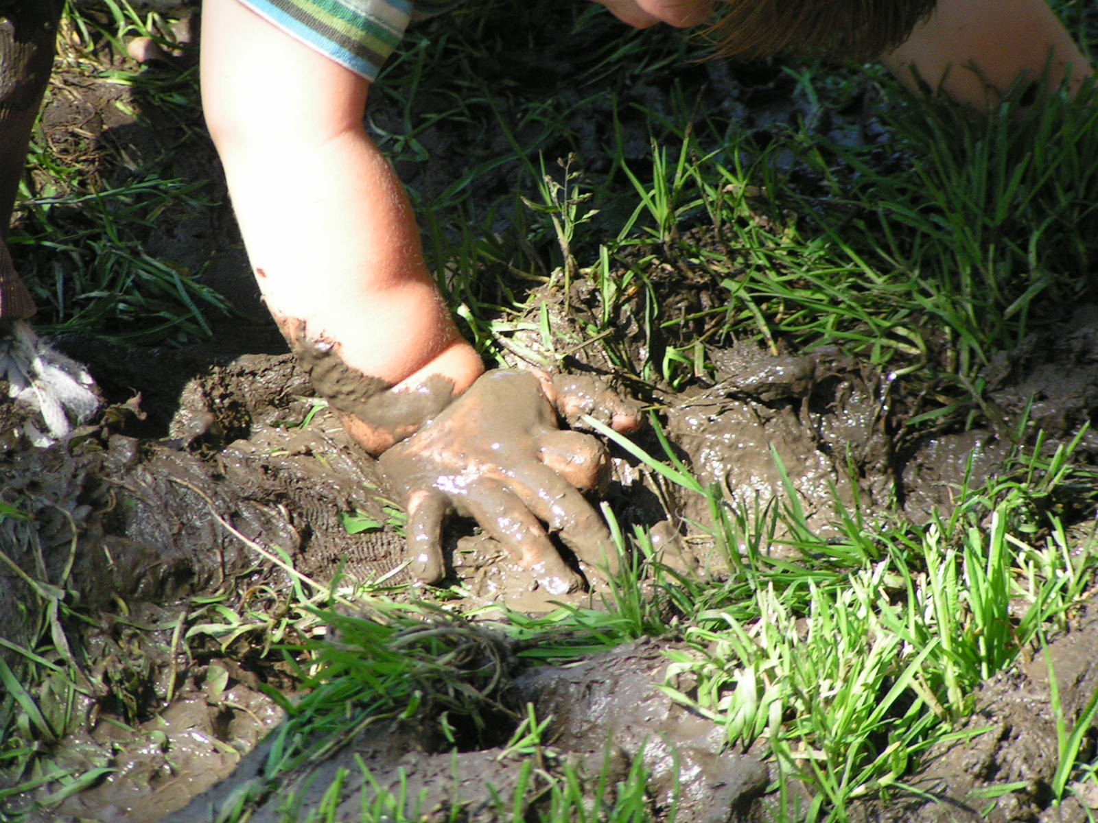 a young child playing in the mud