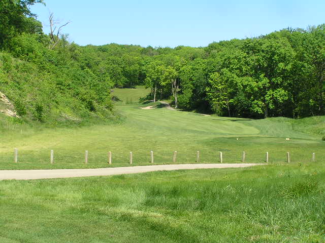 a golf course surrounded by trees and green grass