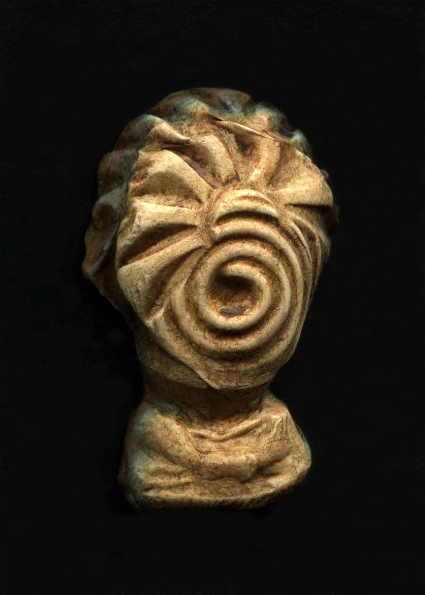 an old statue head is on display with swirls on its side