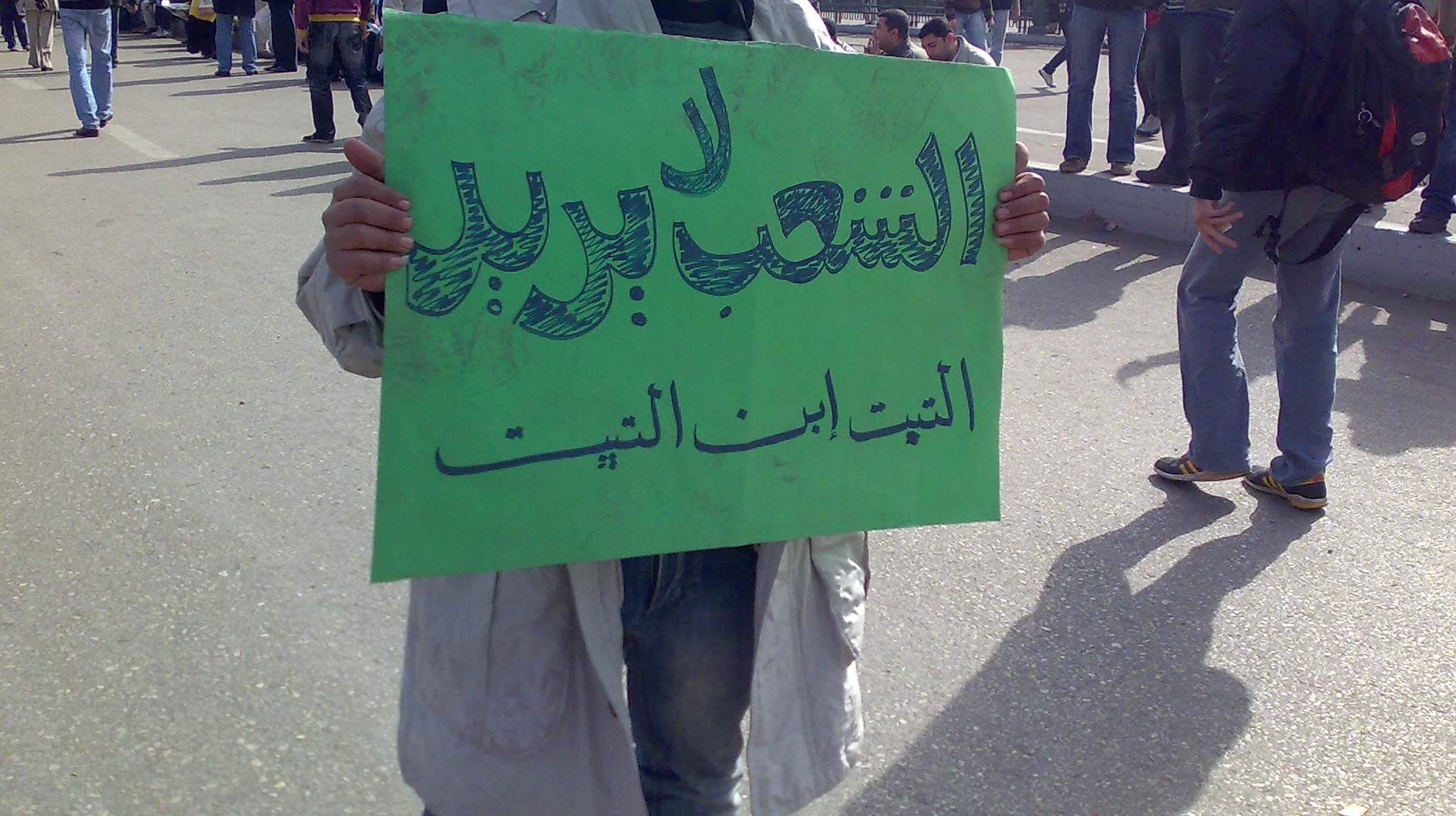 a person holds up a sign while walking