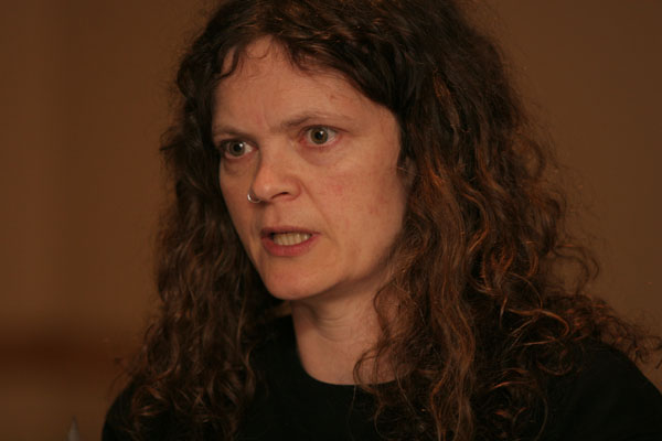 a woman with curly hair is looking at the camera