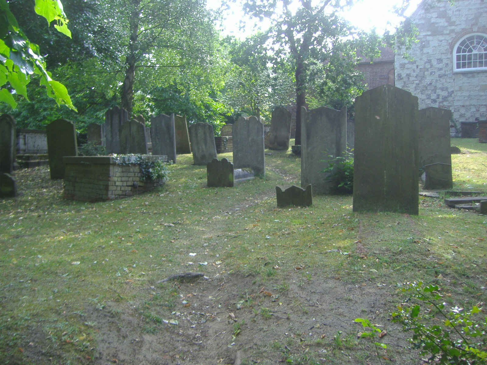 a group of old cemetery graves surrounded by greenery
