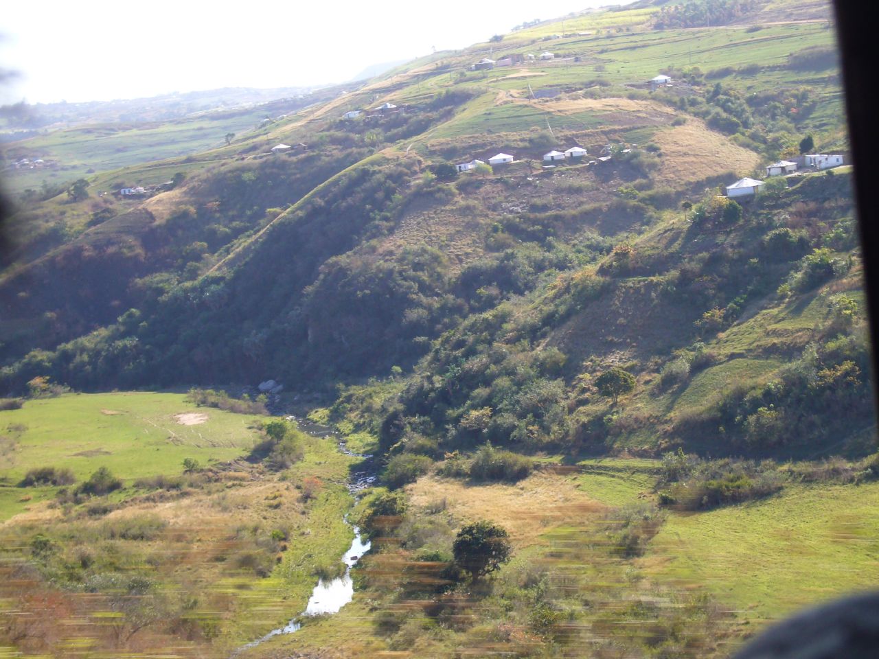 the green mountains have a small stream running through it