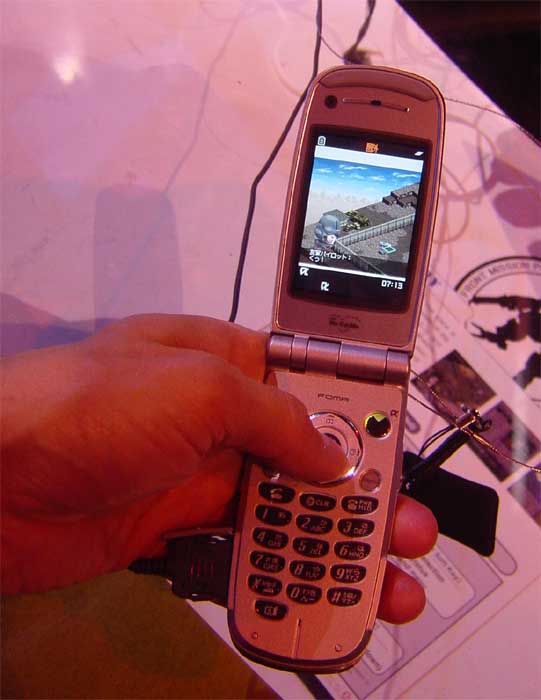a person holding an old fashioned cell phone