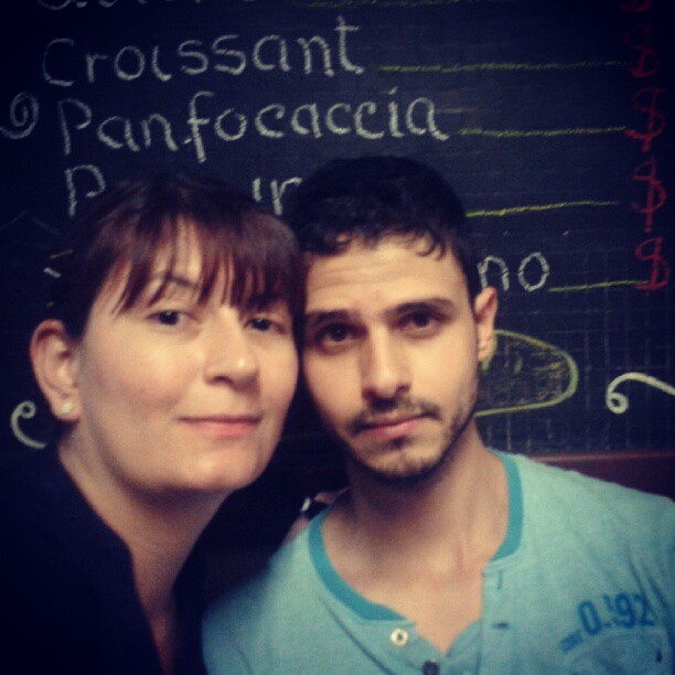 a man and woman pose for the camera in front of a chalk board