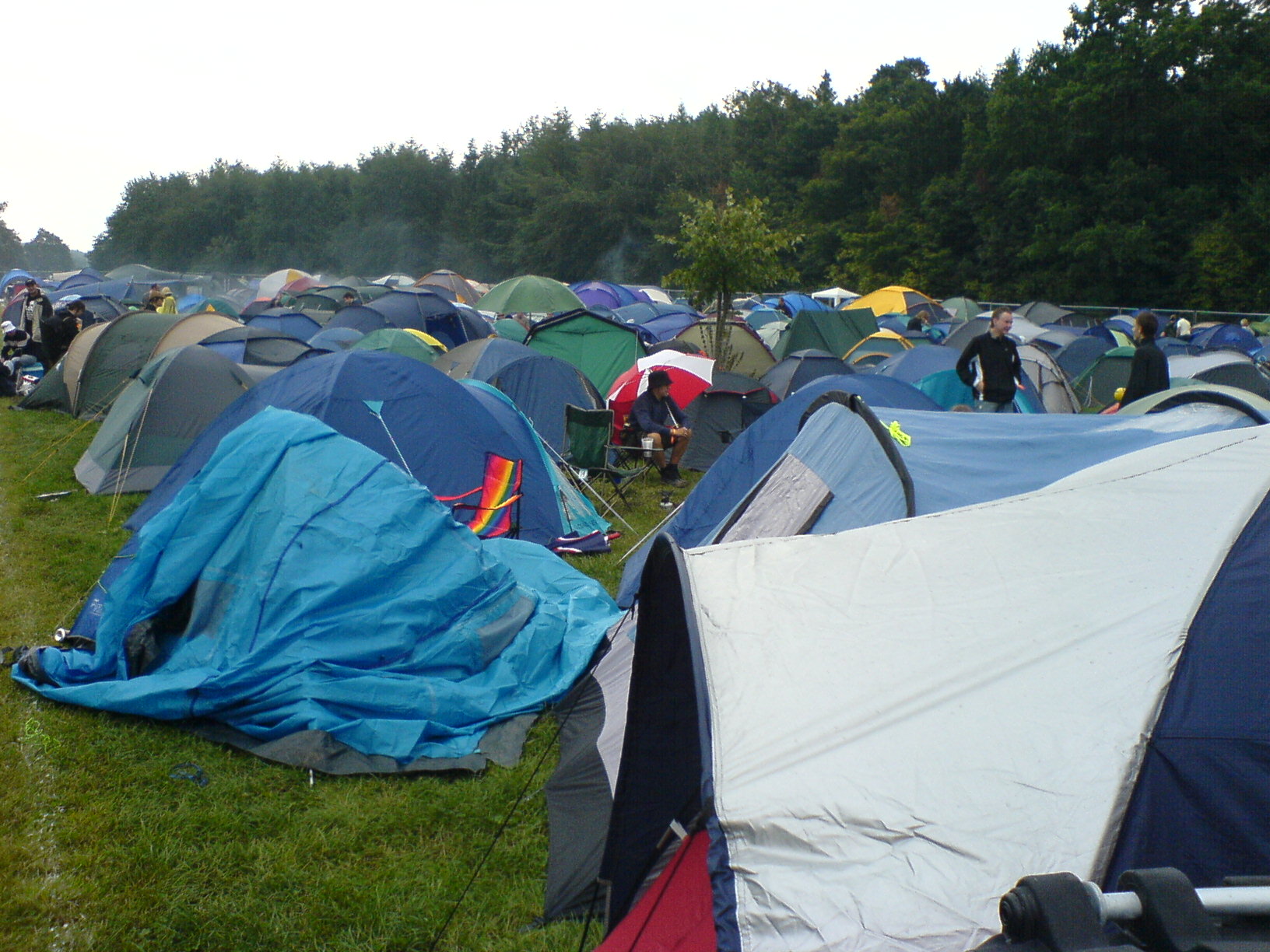 a lot of tents and people next to trees