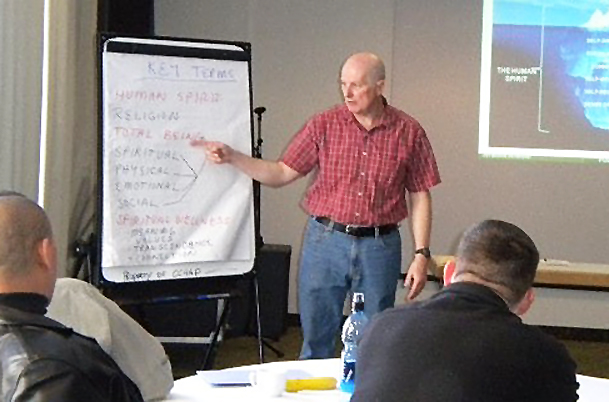 a man giving a seminar to people sitting at a table