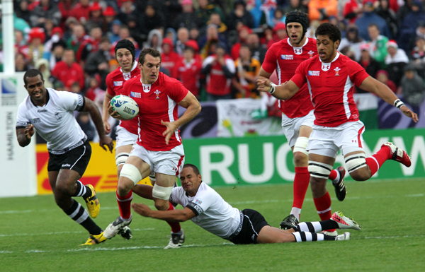 rugby players in a match are trying to block the ball