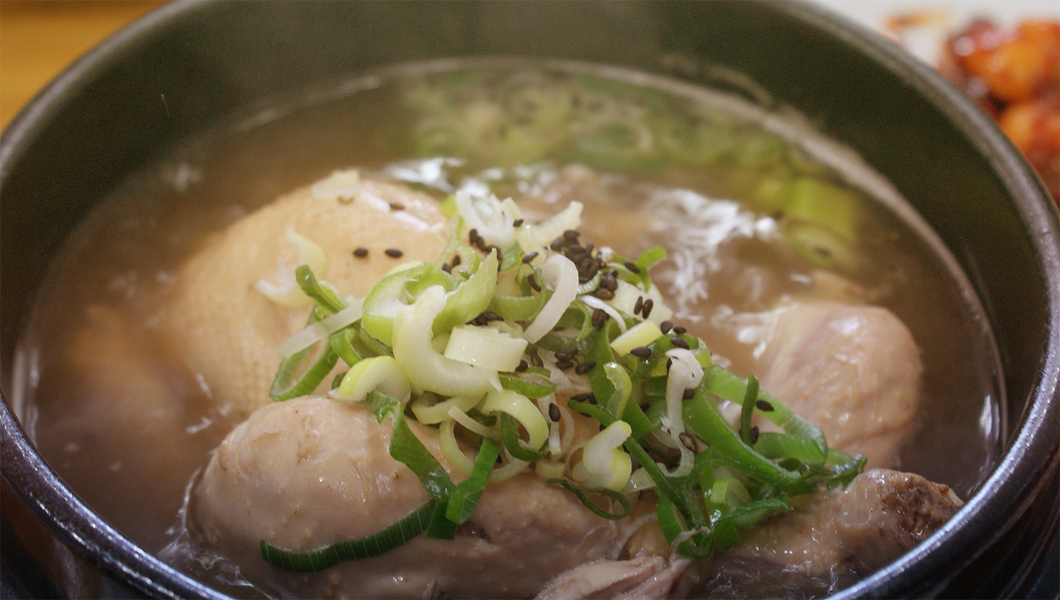 a pot of soup with meat and onions