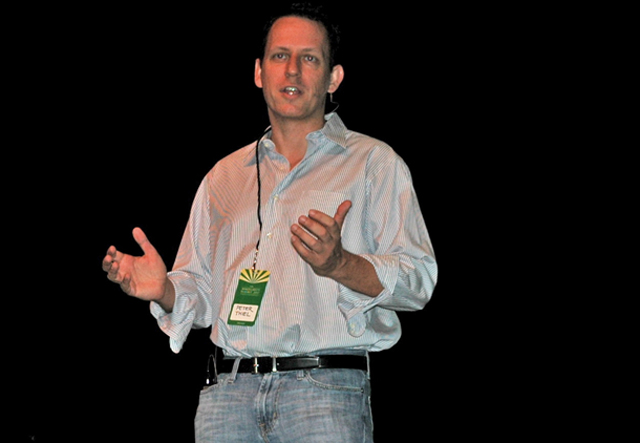 a man giving a presentation on stage with his hands out