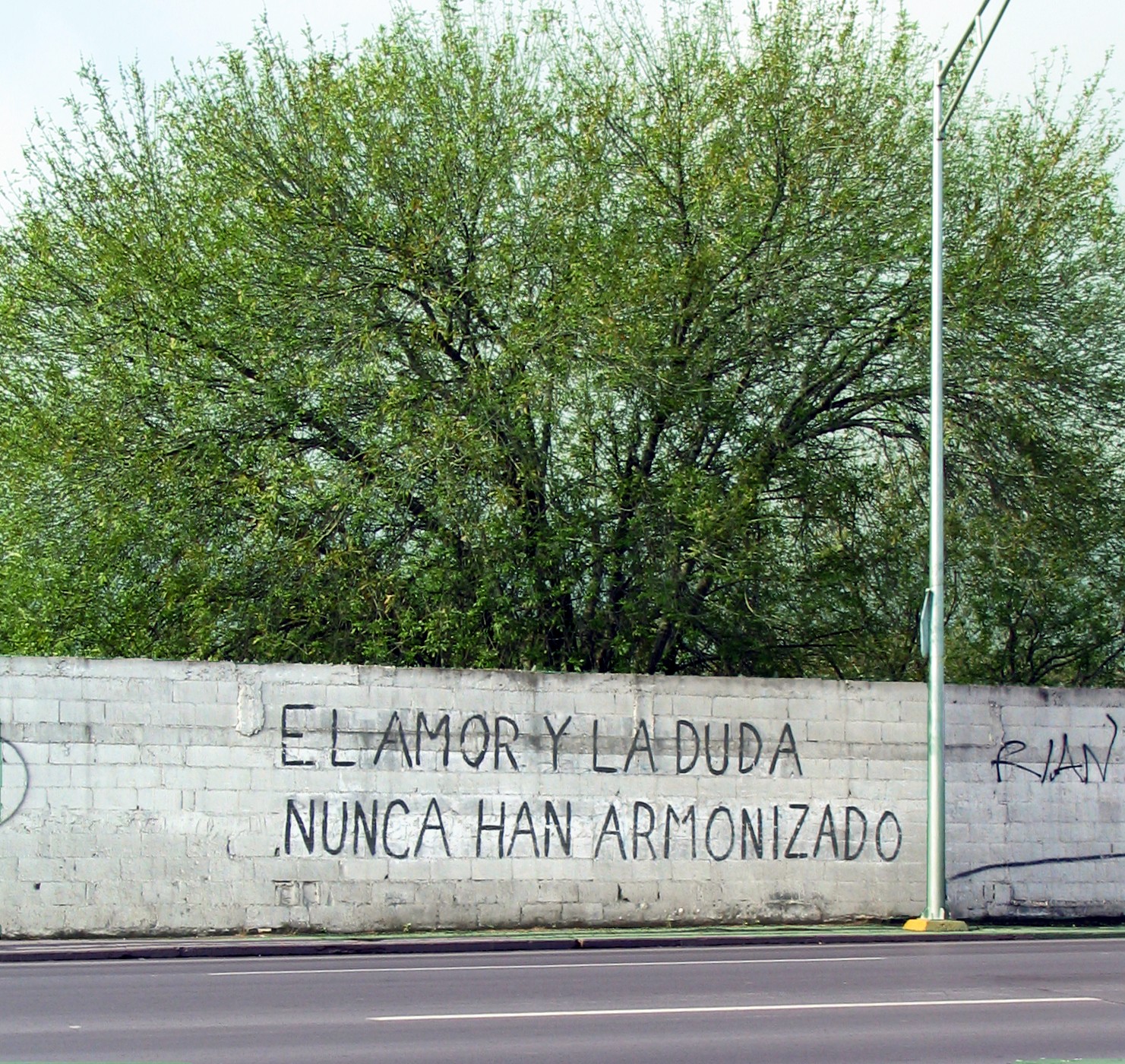 a stone wall with graffiti on the side of it