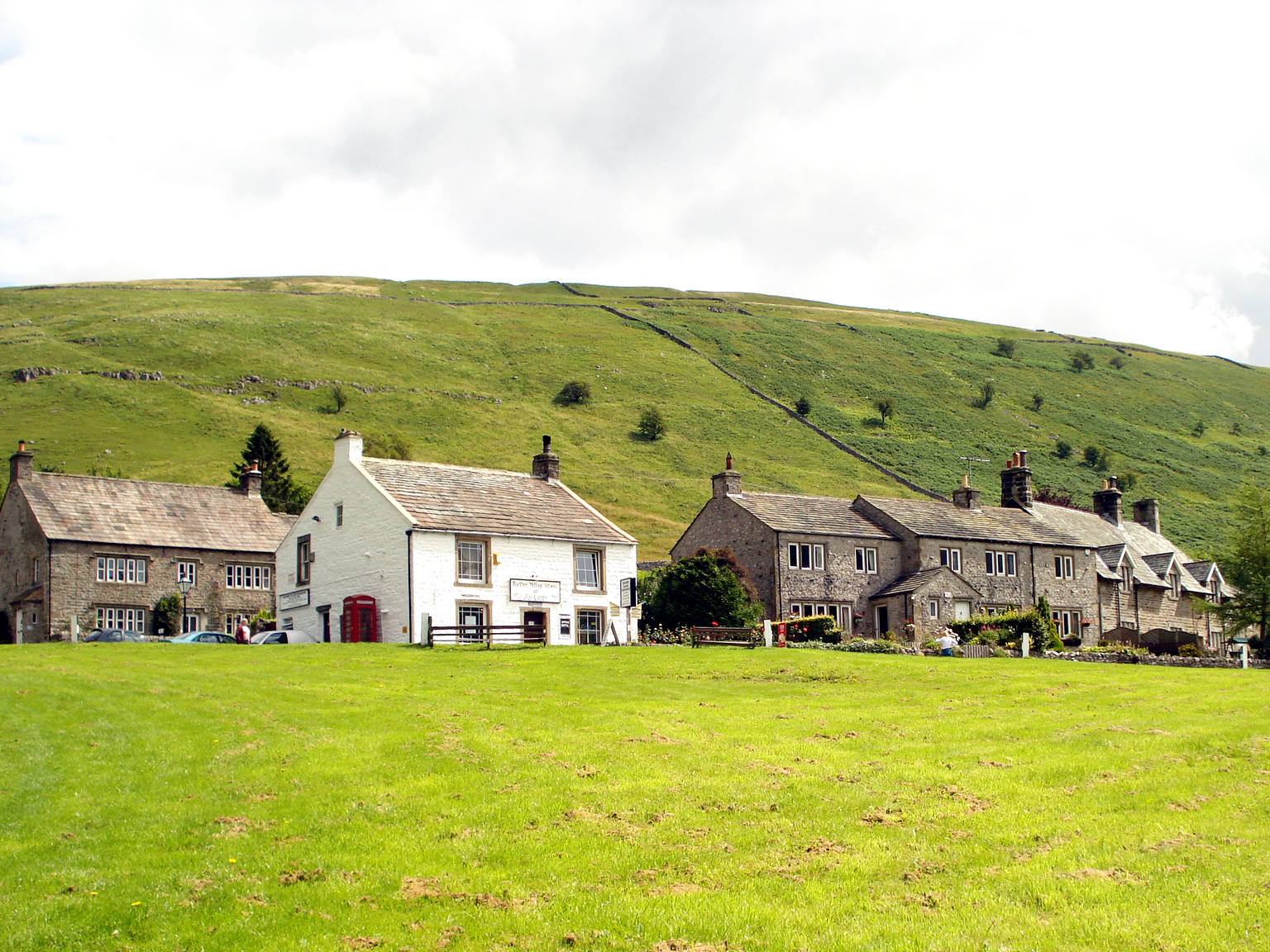 farm houses are nestled on a green hillside