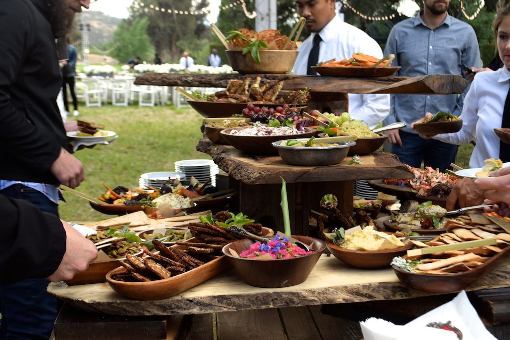 a table full of assorted food is shown with a large wooden platter